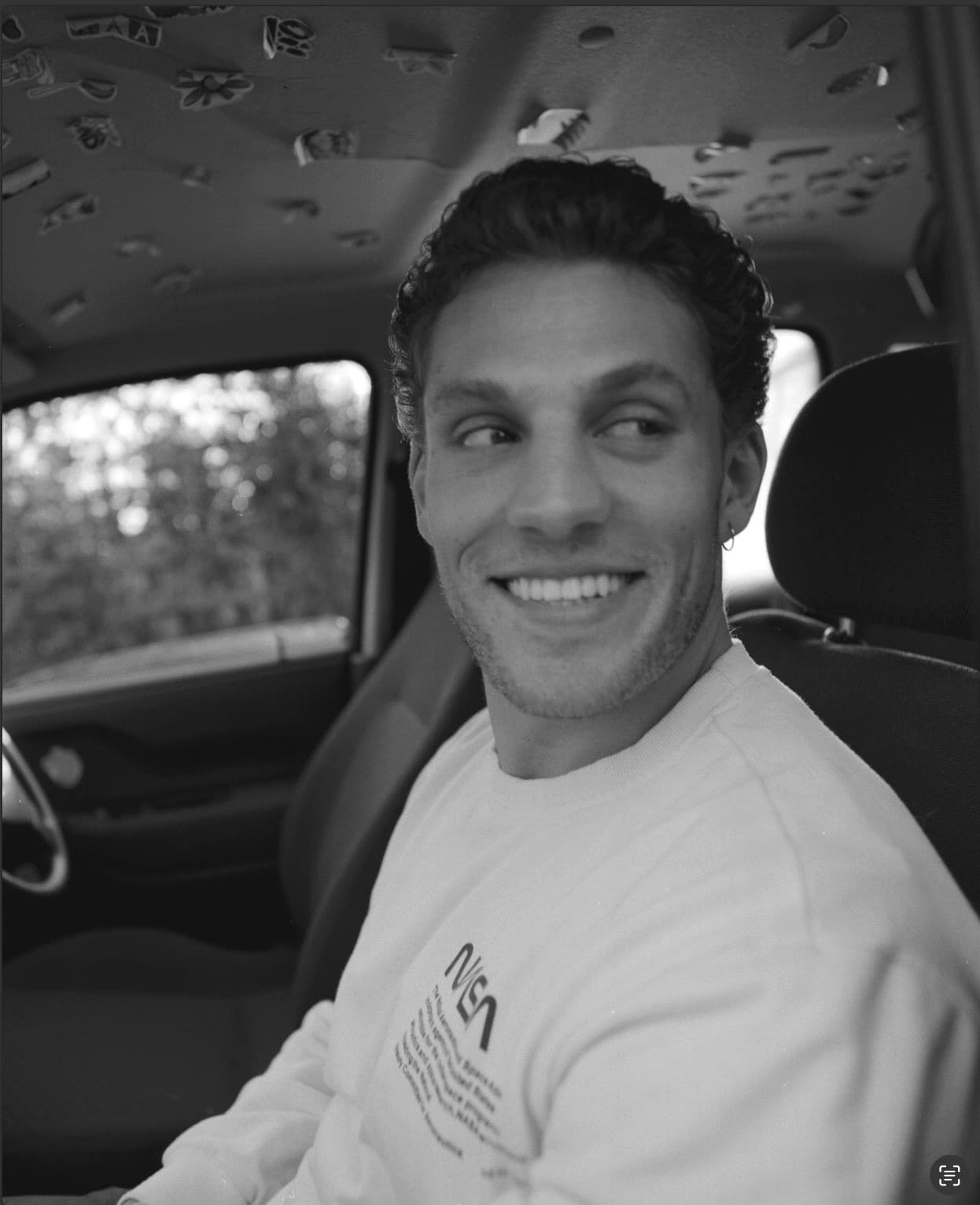 Tristan Alexander casual photo - smiling in a car wearing NASA sweatshirt