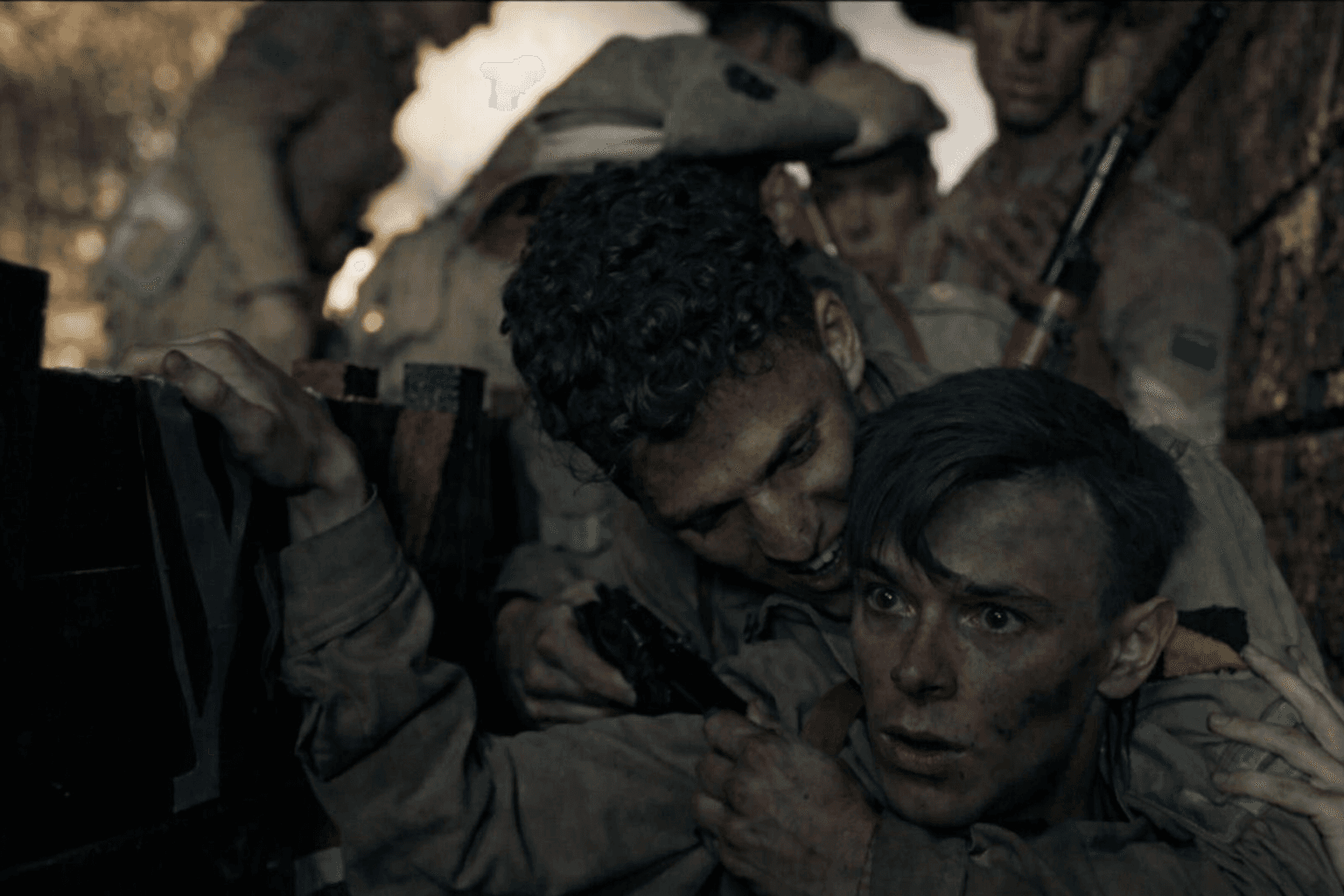 Tristan Alexander in an intense war trench scene, holding a fellow soldier during battle