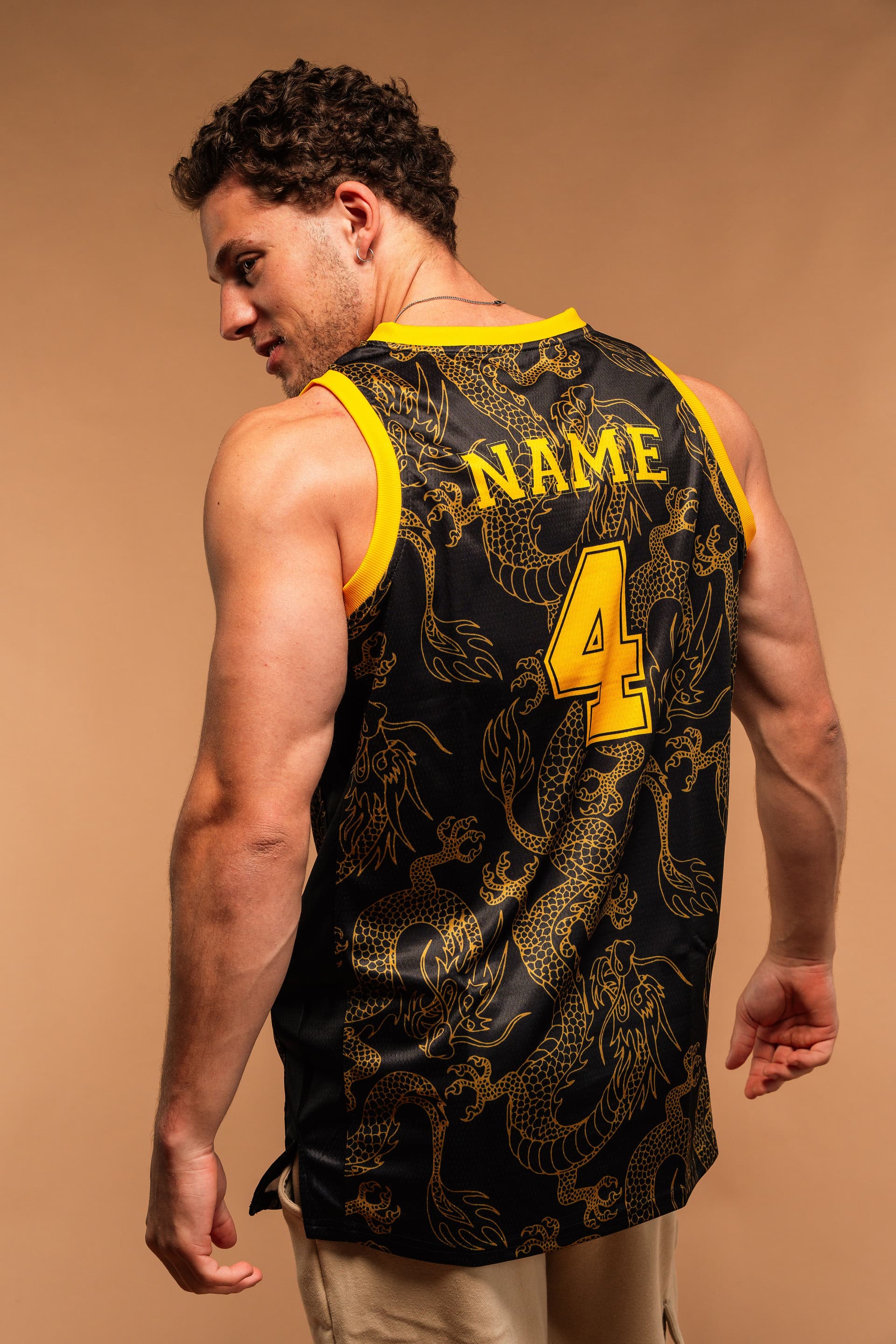 Tristan Alexander from behind wearing a black and gold dragon-print basketball jersey